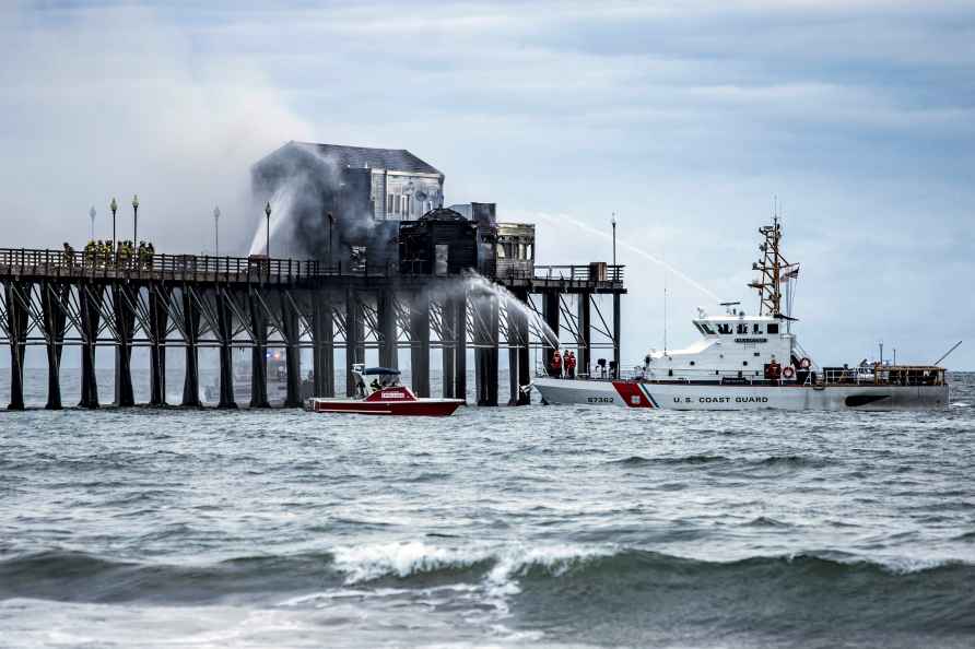 Firefighters battle a fire on a landmark wooden pier in Oceanside...