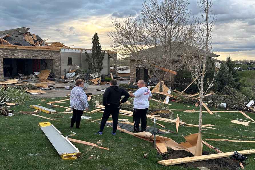 Homeowners assess damage after a tornado caused extensive damage...