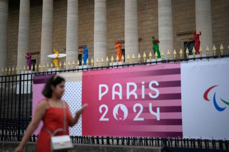 A woman walks past copies of Greek statues,