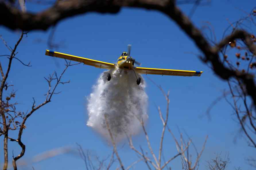 A plane drops water on a fire