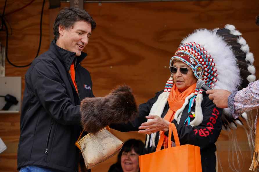 Canada's Prime Minister Justin Trudeau, left, is presented a mitt...