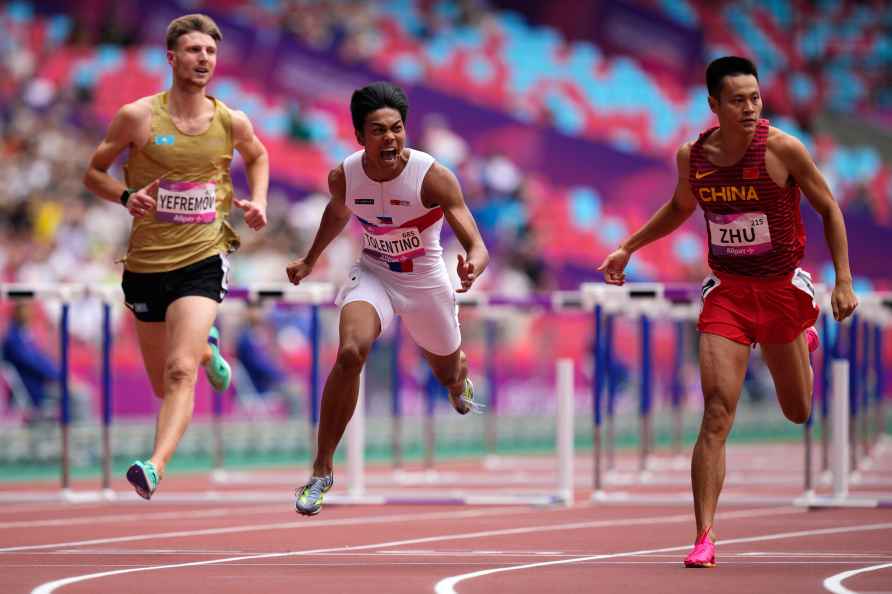 Philippines' John Tolentino, center, reacts as he crosses the finish...