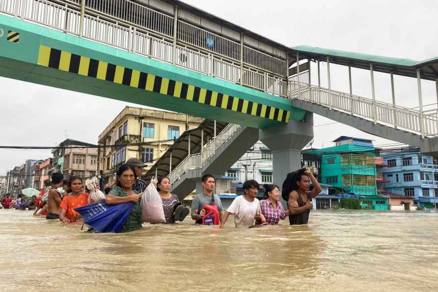 Local residents wade through a flooded road in Bago, about 80 kilometers...