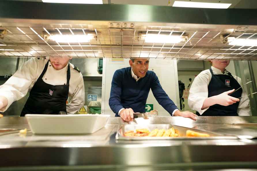 Britain's Prime Minister Rishi Sunak, serves breakfast to the crew...