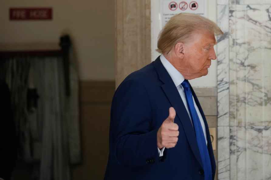 Former President Donald Trump motions as he returns to the courtroom...