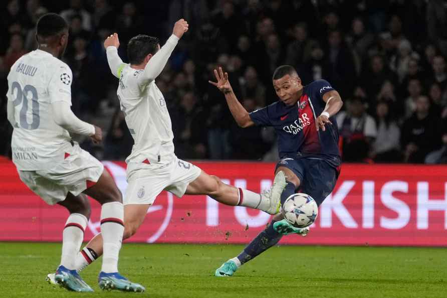 PSG's Kylian Mbappe, right, challenges for the ball with AC Milan...