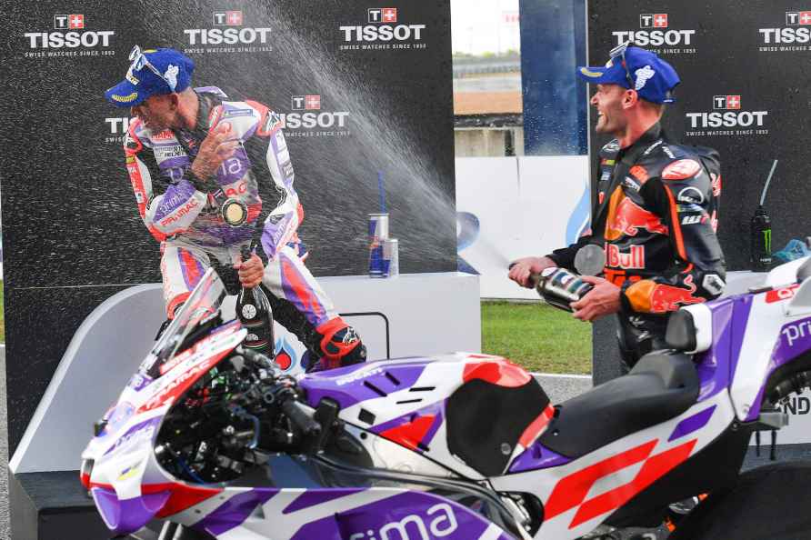 Second placed South Africa's Brad Binder, right, sprays champagne...