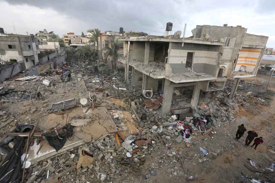 Palestinians look at houses destroyed in the Israeli bombardment...