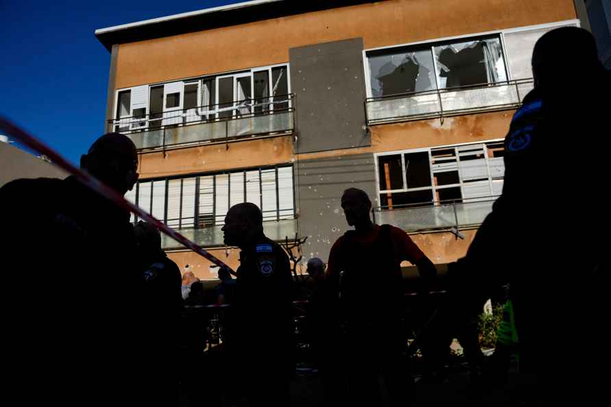 Israeli security forces inspect a site hit by a rocket