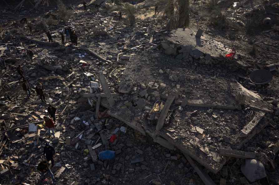 Palestinians inspect a house hit by Israeli bomb