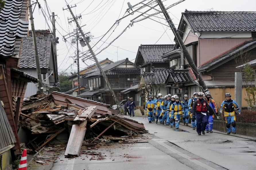 Police walk past collapsed houses hit by earthquakes in Suzu, Ishikawa...