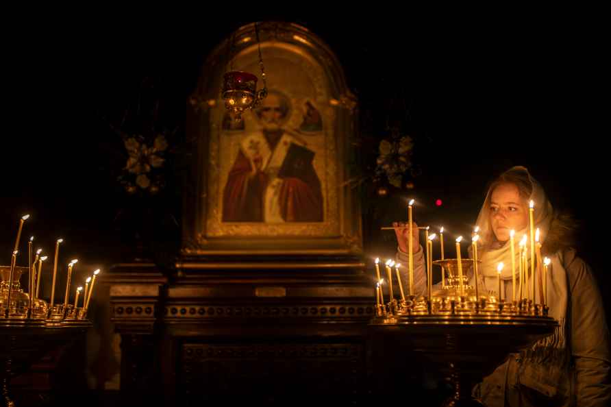 A Lithuanian Orthodox worshipper lights candles before the liturgy...