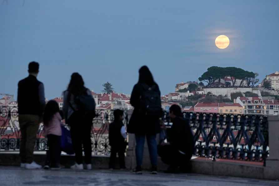 People watch a so-called Wolf Moon, the first full moon of the year...