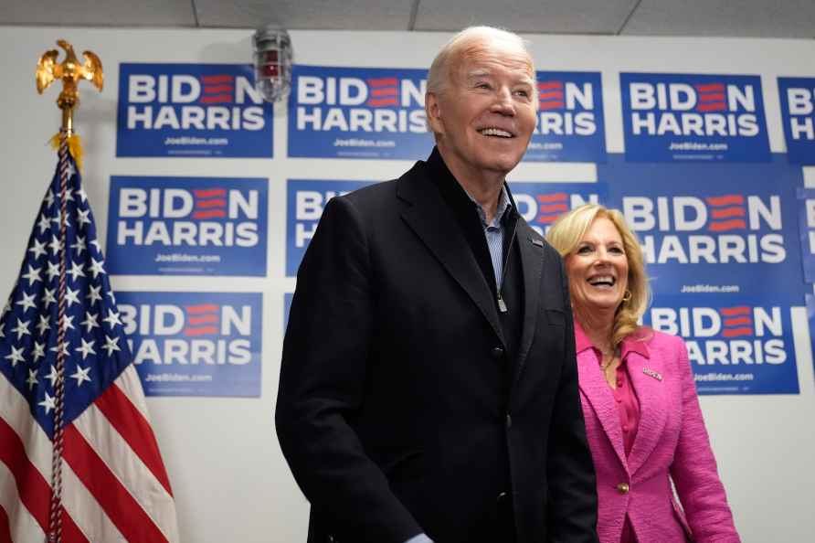 President Joe Biden, left, waits to speak as first lady Jill Biden...