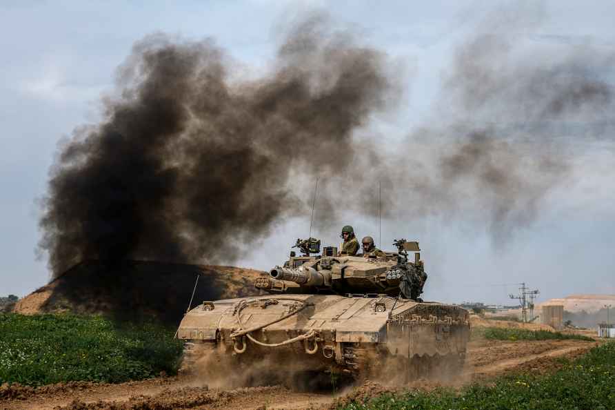 Israeli soldiers drive a tank from inside Gaza Strip