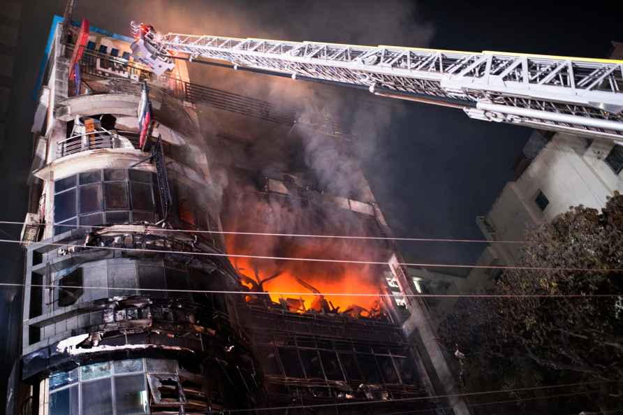 Firefighters work to contain a fire that broke out at a commercial...