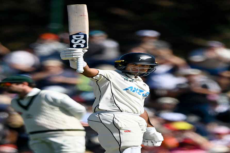 New Zealand's Rachin Ravindra waves his bat on reaching 50 on day...