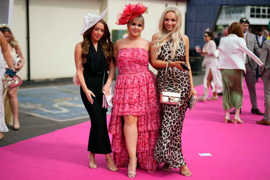 Racegoers pose for photos on Ladies Day, the second day of the Grand...