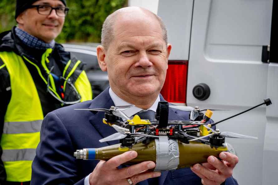 German Chancellor Olaf Scholz holds a replica of a drone, that is...