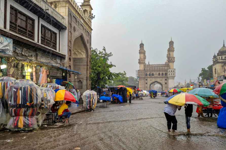 Hyderabad: Commuters and shopkeepers on a flooded road amidst rains...