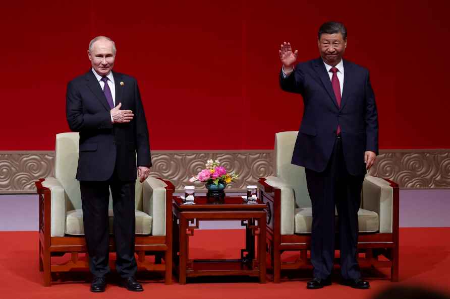 Russian President Vladimir Putin, left, and Chinese President Xi Jinping greet spectators