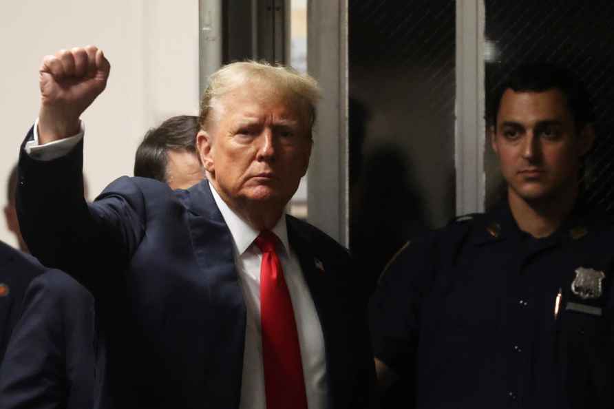 Former President Donald Trump reacts as he walking back into the...