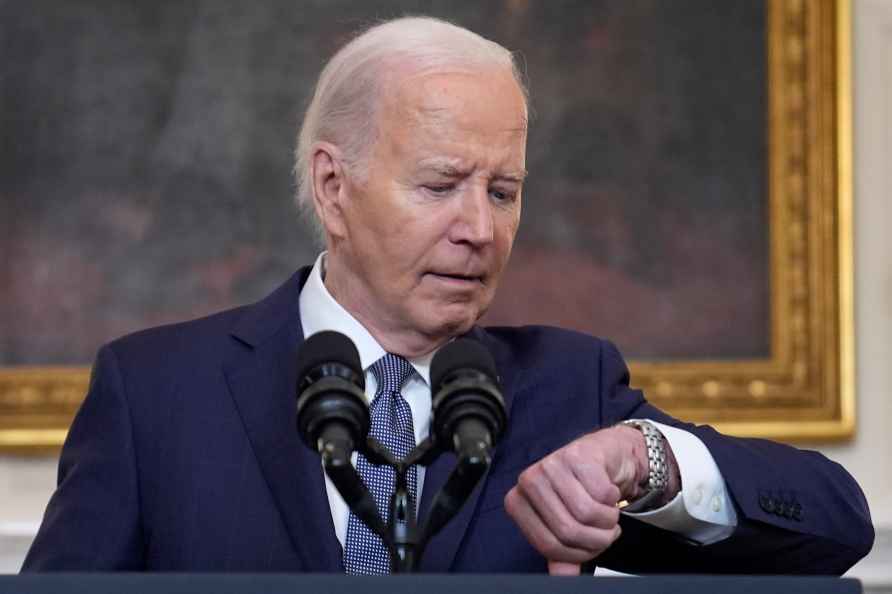 President Joe Biden checks his watch before delivering remarks on...