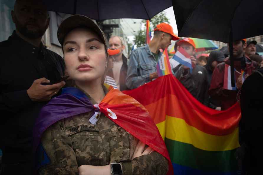 A woman soldier wrapped in the LGBT flag