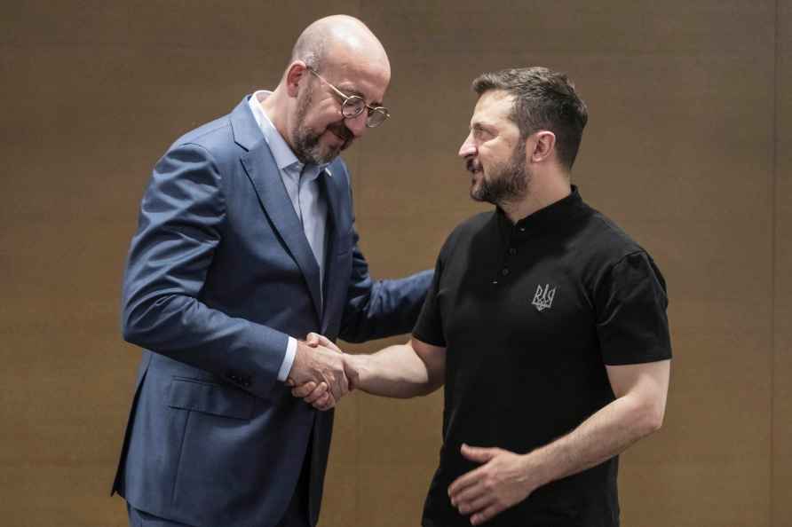 Ukrainian President Volodymyr Zelenskyy, right, shakes hands with...