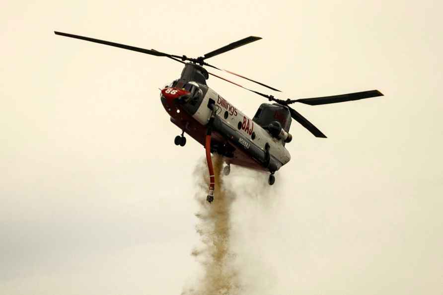 A helicopter drops water on the Apache Fire