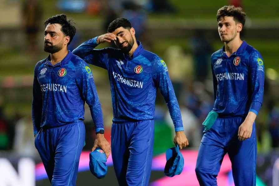 Afghanistan's captain Rashid Khan, left, walks with his teammates...