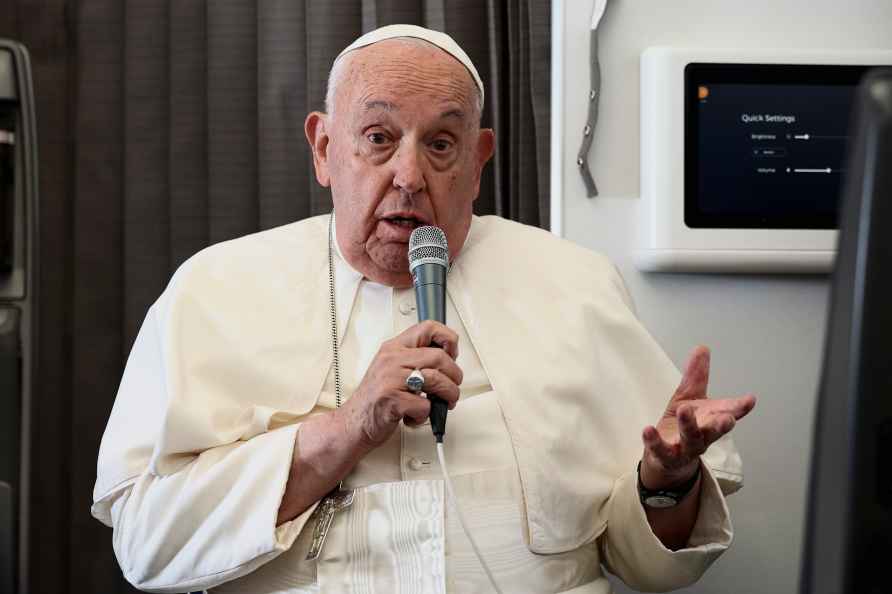 Pope Francis holds a news conference aboard the papal plane on his...