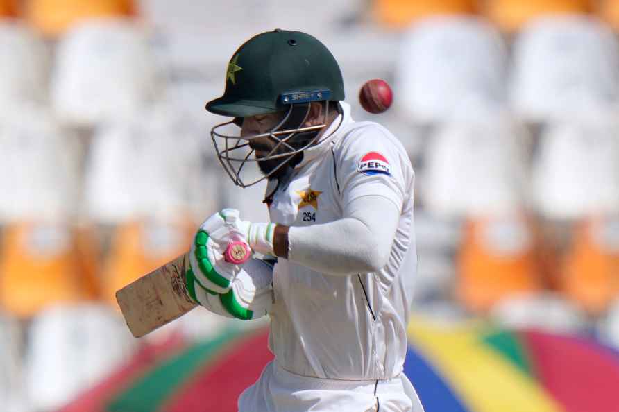 Pakistan's Aamer Jamal reacts after a delivery hitting on his helmet...