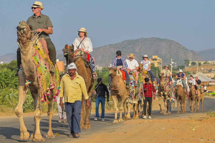 Ajmer: Foreign tourists take camel rides at the Pushkar Fair 2024...