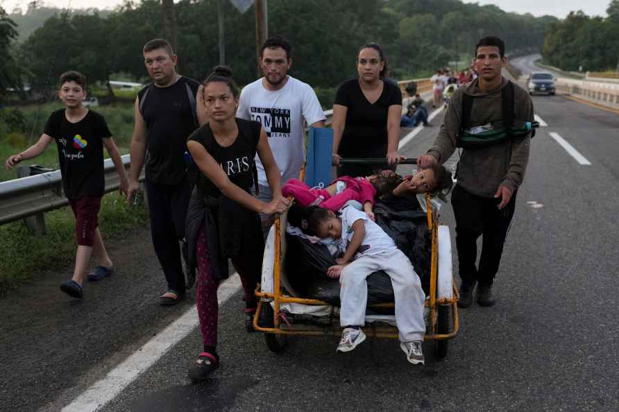 Migrants walk along the Huixtla highway