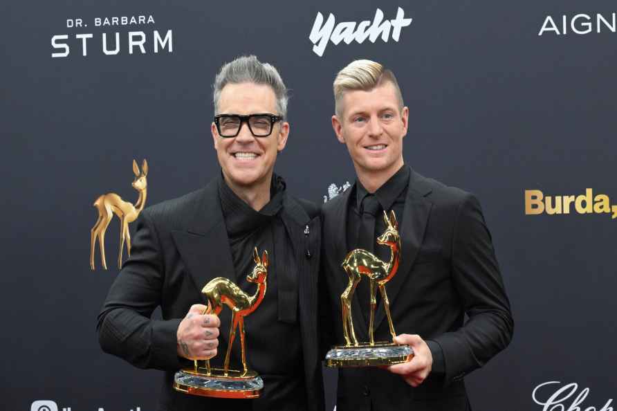 Robbie Williams, left, winner in the 'Entertainment' category, stands...